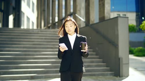 Confident manager Businesswoman walking urban street near big modern Business district. Young asian