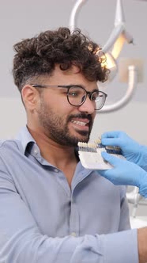 Man at Dentist Matching Shade to his Teeth