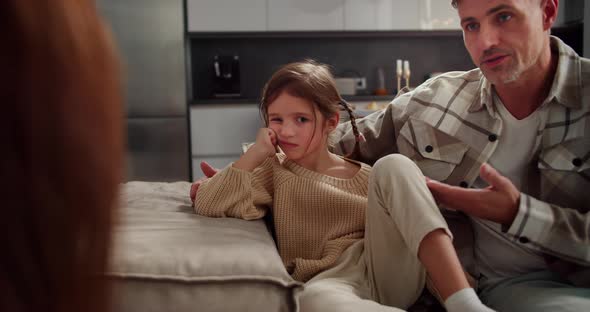 Sad and Indignant Little Girl Sits on the Sofa and Listens to Her ...