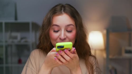 Young Woman Uses Smartphone Indoors