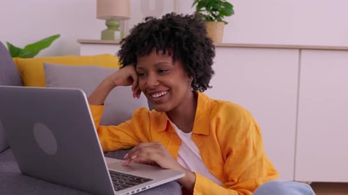 Smiling Woman Using Laptop on Floor in Living Room