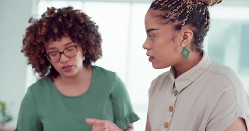 Women Discussing Paperwork in Corporate Office