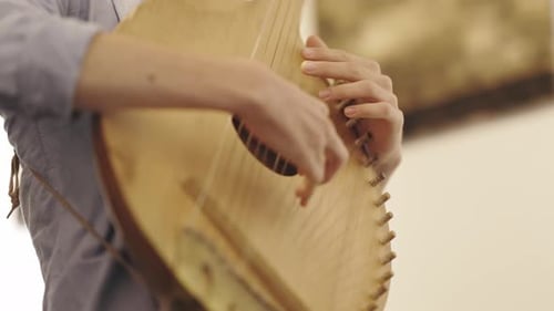 Close Up of Hands Playing Stringed Instrument