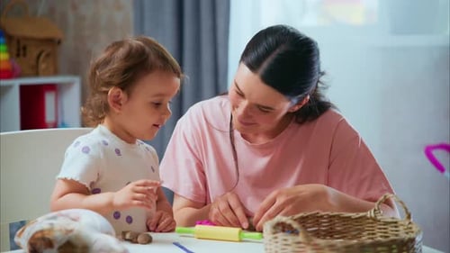 Woman and Child Play with Clay Indoors