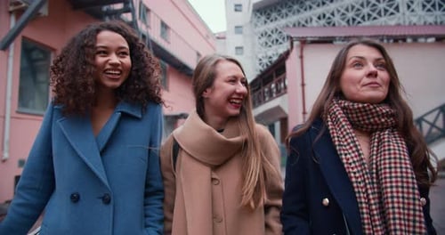 Three Friends Walking and Talking in City Street