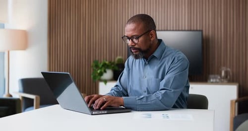 Business, black man and typing in office with laptop for data analysis, financial planning or audit