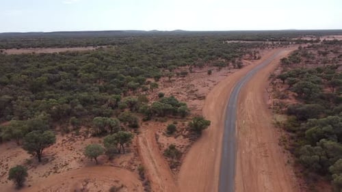 Drone descending and landing on a sealed country road in the Australian Outback