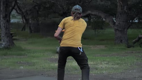 Man throwing a Frisbee long distance. Camera stays on man.