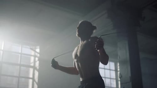 Powerful Male Athlete Jumping Skipping Rope In Slow Motion. Muscular Man Exercise Jump Rope At Ca...