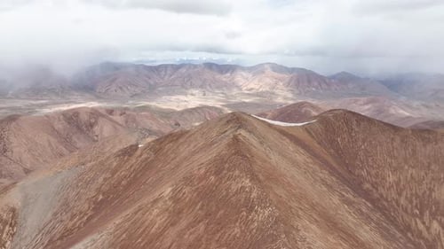 Sharp, eroded mountain ridges and vast arid valley in Central Asia