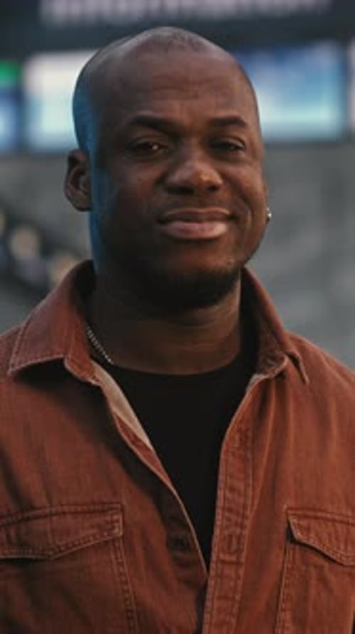 Calm and Smiling Male Traveler in Stylish Red Shirt in Busy Airport Terminal