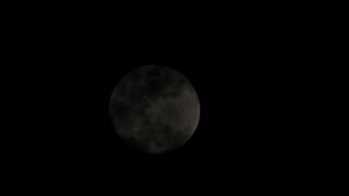 Dramatic Night: Full Moon Rising Through Wispy Clouds