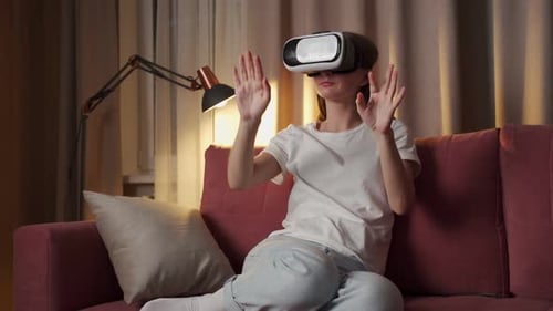 Woman Using VR Headset on Red Couch