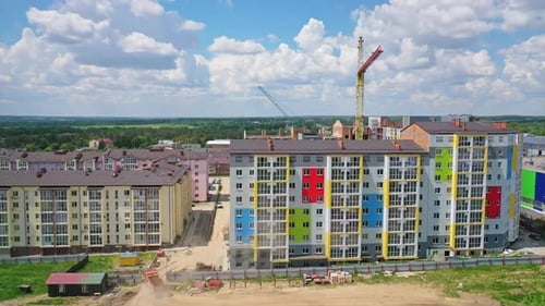 New high rise building with colorful exterior. Construction site with modern apartments in the city.