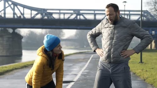 Pareja de corredores cansados que se toman un descanso de correr en City Active