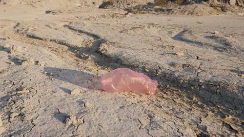Una bolsa de plástico vuela en tierra seca: desastre ambiental