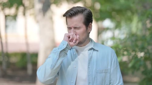 Outdoor Portrait of Young Man Coughing