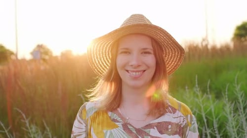 Portrait of Smiling Woman in the Straw Hat Standing in the Field
