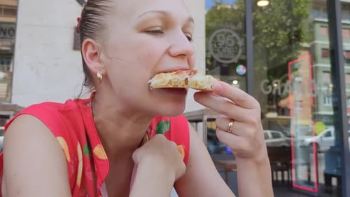 Woman Eating Pizza Outside at a Restaurant