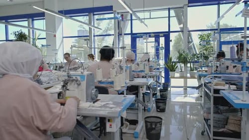 Frauen in der Nähproduktion arbeiten während des Arbeitsprozesses für Nähmaschinen Media Garment Factory