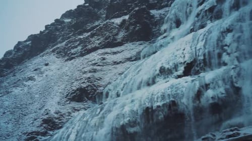 Cascada helada que cae por un acantilado. Desplazar a la derecha, alejar