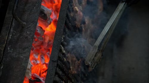 Zeitlupe eines Kochs mit schwarzen Handschuhen, der saftige Rindersteaks auf einem Grill mit gr umdreht