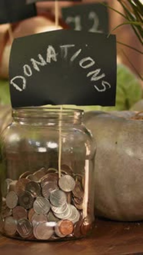Vertical Video Farmers Market Table with Fresh Produce and Jar of Donations