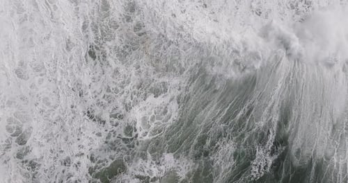 Beautiful nature aerial drone shot of big Atlantic ocean waves coming into shore on a day with
