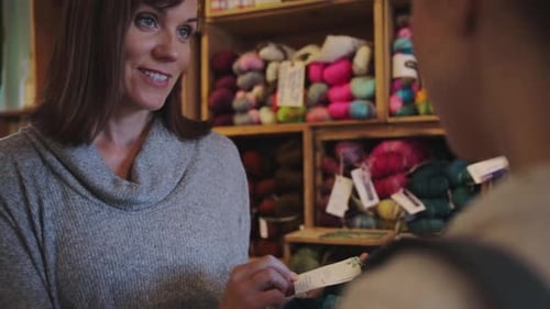 Calgary yarn store owner helping customer with knitting wool choice