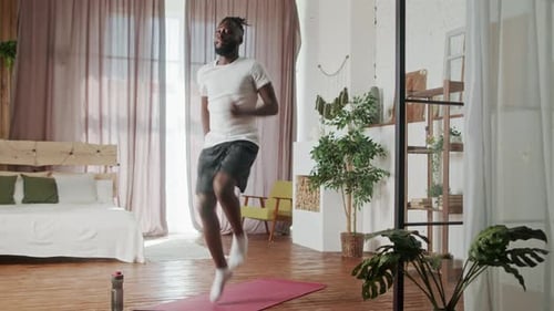 Young Adult Exercising at Home on Yoga Mat