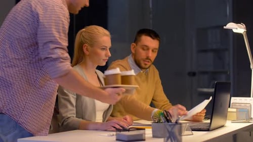 Hispanic business team fuels deadline push with coffee and laptops in modern office