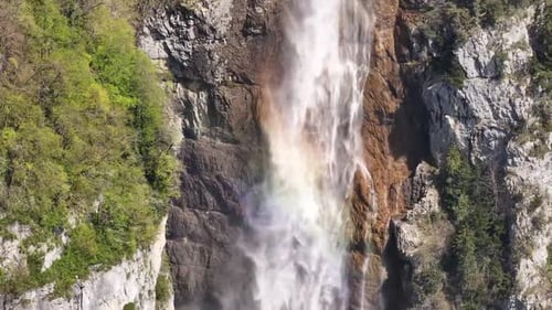 Breathtaking aerial image of the Seerenbachfälle waterfall with a beautiful rainbow.