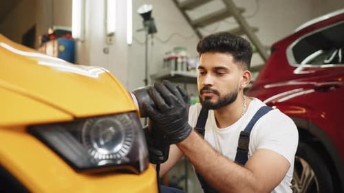 Man Polishing Yellow Car in Garage