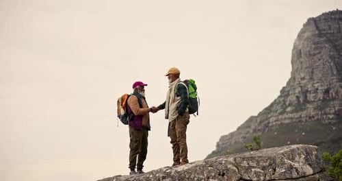Men, friendship and handshake on mountain for support, achievement and fitness goal