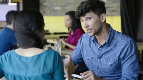 Happy young hispanic couple enjoying lunch together at restaurant