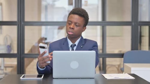 Young Professional Man Using Smartphone at Desk