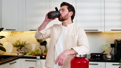 Middleaged Man Enjoying Protein Shake in Home Kitchen After Workout for Fitness Diet Nutrition Plan