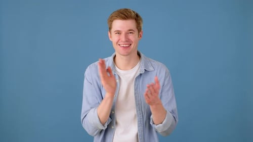 Smiling Young Adult Clapping and Pointing to Camera