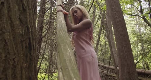 Black Girl In The Woods Caressing Fallen Tree, Looking At Camera. Wide Shot 60fps Slow Motion.