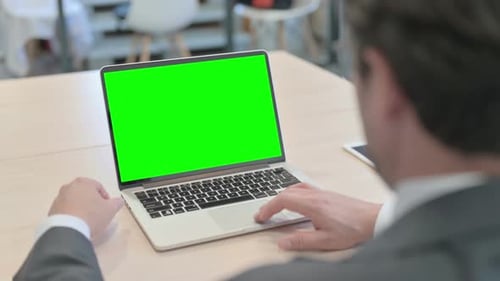 Businessman Working on Computer with Green Screen in Office