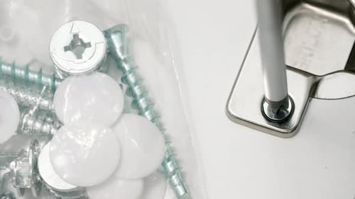 Silver Screw Being Screwed into Metal Hinge
