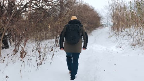 Caucasian Hiker Walk Embracing Winter Snowy Trek in Slow Motion Back View