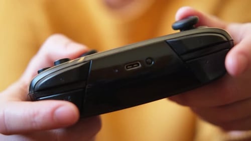 Hands Holding a Black Video Game Controller