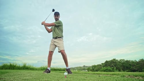 Sports Man at Golf Course Playing Game in Nature and Hitting Ball with Club