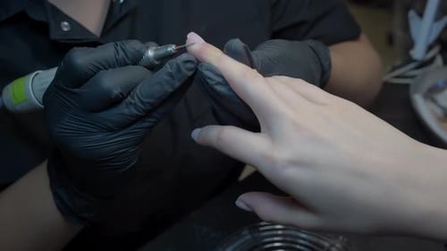 Close Up Side Angle Manicurist Filing Nails Generating Dust