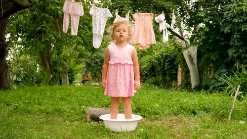 The Child is Washing Clothes in the Garden Selective Focus