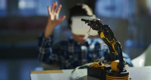 Boy Using Virtual Reality with Robotic Arm