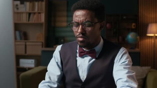 Male Professor Working on Computer at Desk in Home Office