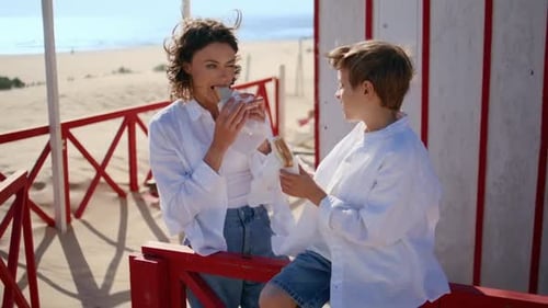 Mother and Son Enjoy Sandwiches on the Beach