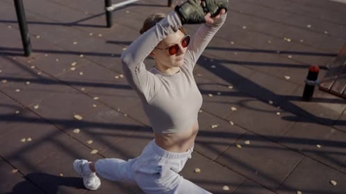Young Woman Doing Stretching Exercises in Park